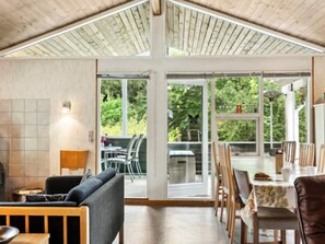 A spacious room with a high ceiling, large windows, and a view of greenery outside. - 8 Person Holiday Home in Ans By (Ans)