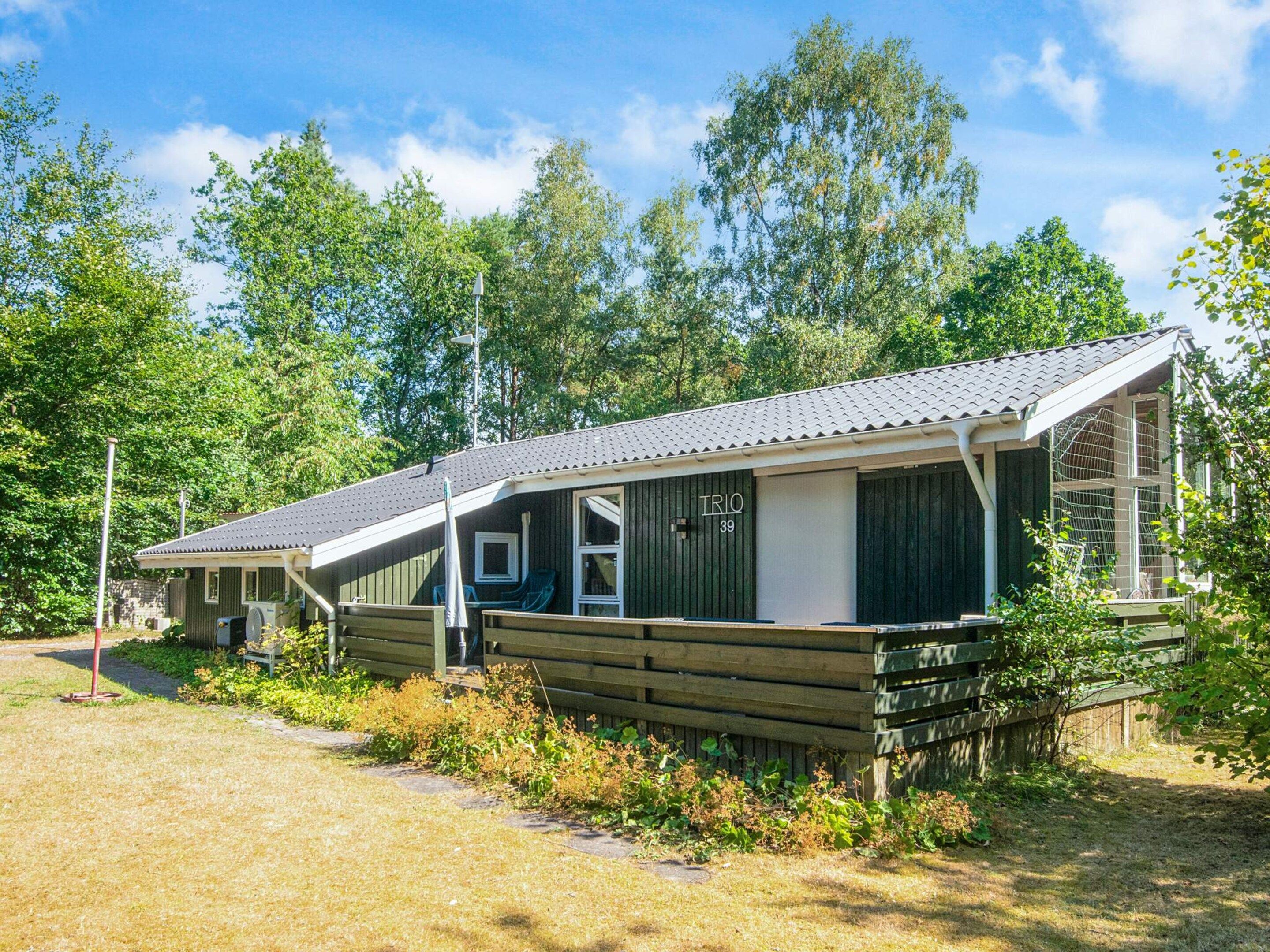 A row of cabins with a covered porch, numbered 39, surrounded by trees.