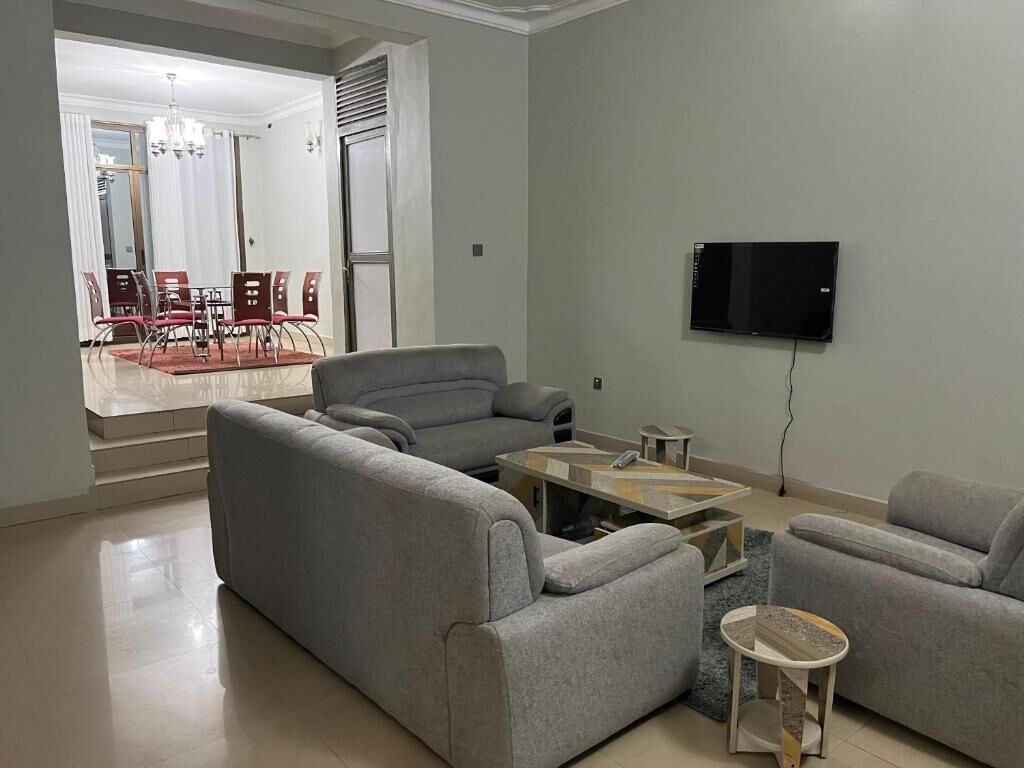 Una sala de estar con sofá, mesa de centro y televisor.