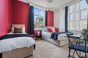 A bedroom with two beds, a desk, and a window with curtains. - Triple Studio Flat (Sleeps 3) with Parking | CV2 (Coventry)