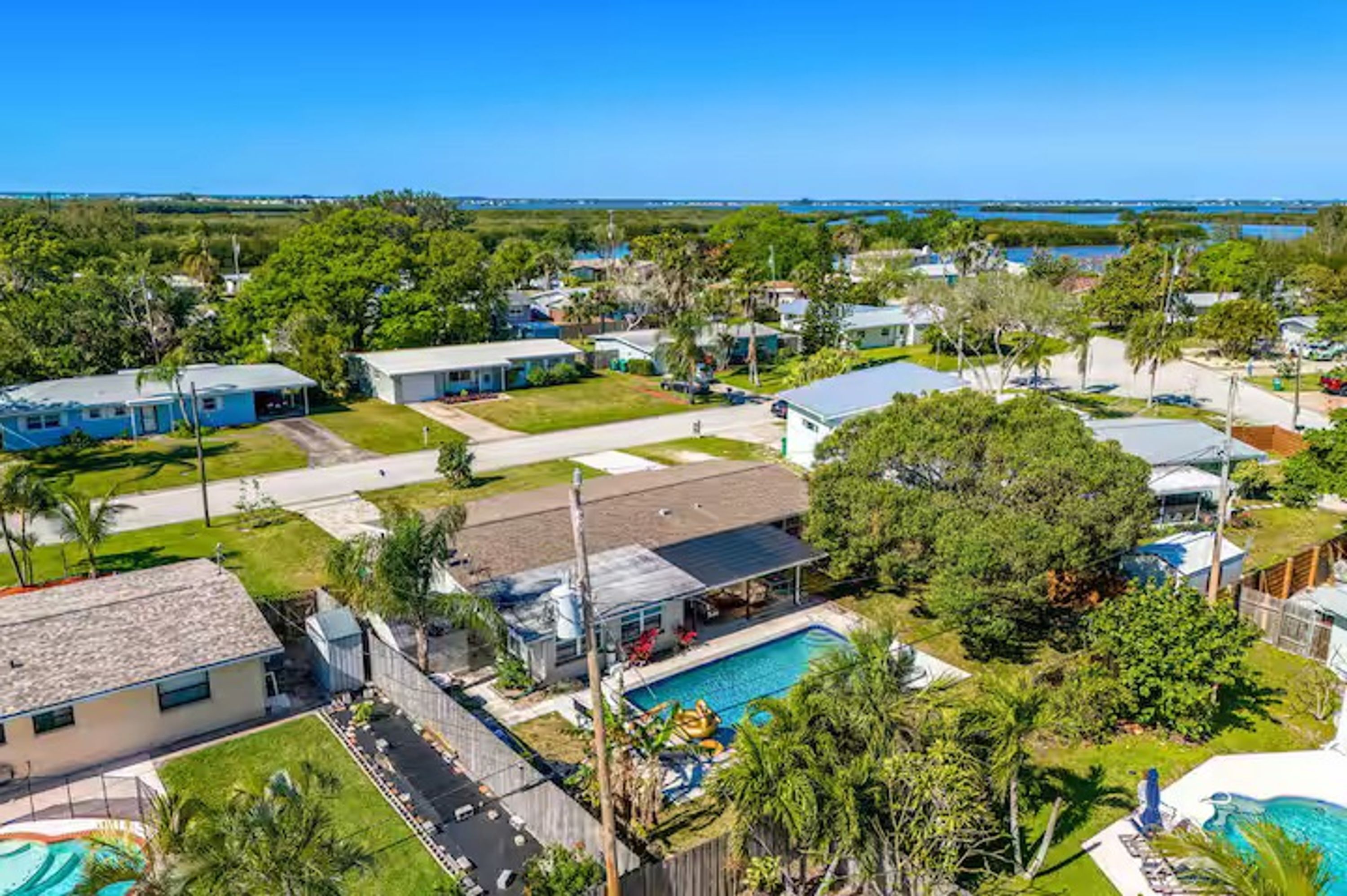 Zona residencial con casas, piscina y vista al océano.