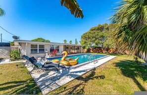 Ein Wohngrundstück mit Swimmingpool, Luftschwan und einem Haus mit Satellitenschüssel.
