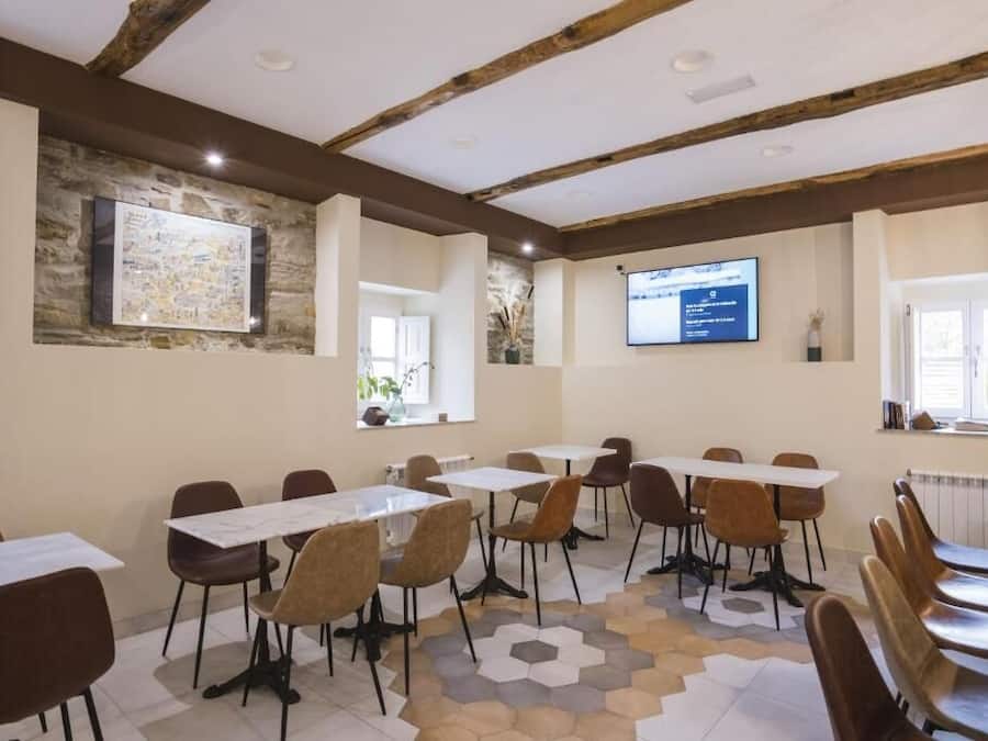 Ein Konferenzraum mit Tischen, Stühlen, einer Projektionsleinwand und einer Steinwand mit einer gerahmten Karte.