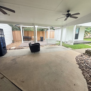 A covered patio area with a ceiling fan, a bench, and a trash bin. - 3-bedroom house in beautiful Spring with amazing Pool (Spring)