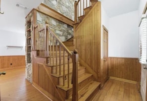 A wooden staircase with a stone accent wall leading to a door. - 3-bedroom house in beautiful Spring with amazing Pool (Spring)