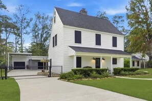 A two-story house with a front porch, a garage, and a well-maintained lawn. - 3-bedroom house in beautiful Spring with amazing Pool (Spring)