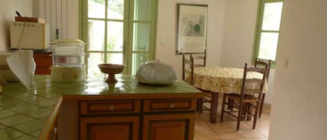Una cocina con mesa, sillas y ventana.