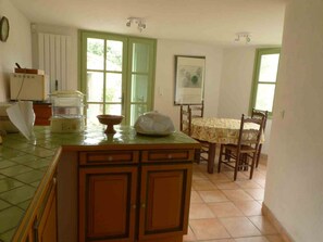 A kitchen with a dining table, chairs, and a window. - Country House, Cévennes 30 (Gard) (Saint-Laurent-le -Minier)