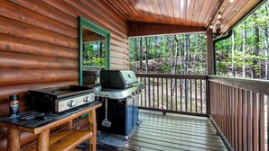 A wooden deck with a grill and a table with a can of Nufziger BBQ sauce. - 5 min to Aska Adventure area! Hot Tub + Fireplace, Dog Friendly, Fire pit (Blue Ridge)