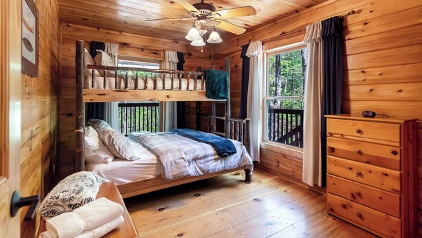 A cabin with a bunk bed, a wooden ceiling fan, and a window with curtains. - 5 min to Aska Adventure area! Hot Tub + Fireplace, Dog Friendly, Fire pit (Blue Ridge)