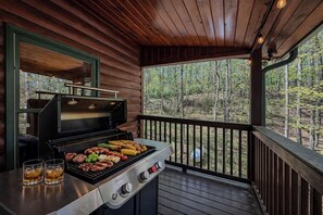 Un espace barbecue extérieur abrité, avec vue sur la forêt.