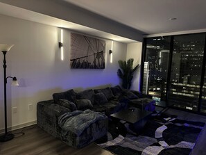 A modern living room with a sofa, coffee table, and floor lamp. - Downtown Beauty (Atlanta)