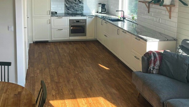 A modern kitchen with white cabinets, a marble backsplash, and a built-in oven. - Lakeside cottage with private beach in Sörmland (Stavsjö)
