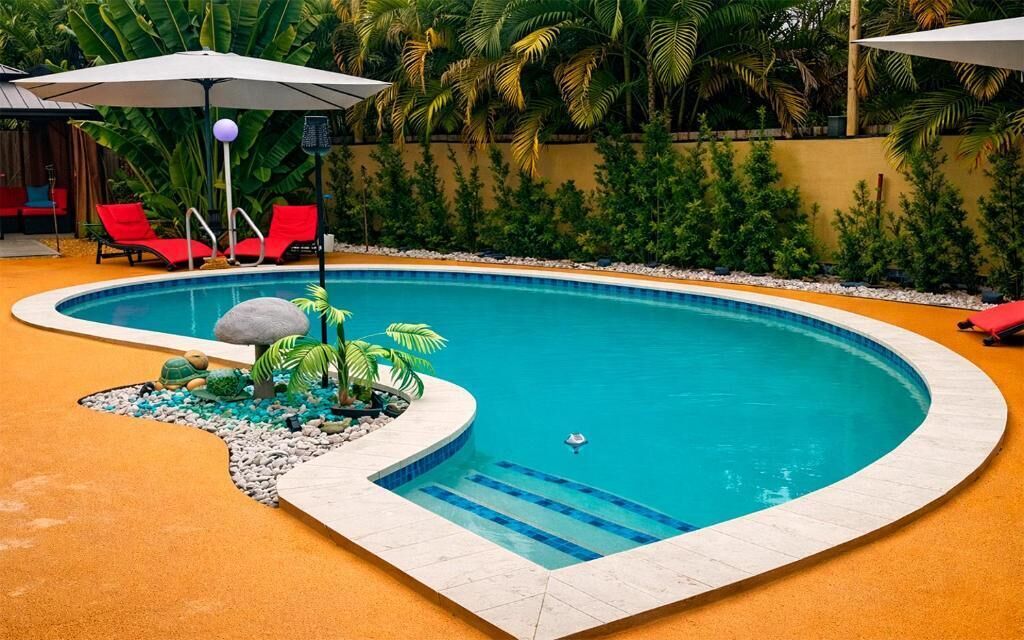 Una piscina al aire libre, sombrillas, tumbonas