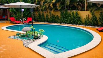 Una piscina al aire libre, sombrillas, tumbonas