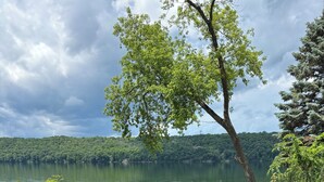 Area esterna con posti a sedere lungo il lago, completa di un braciere, una sedia e un kayak.