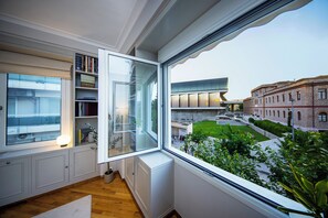 Ein Zimmer mit einem großen Fenster, einem Bücherregal und einer Heizung.