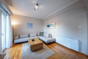 Ein modernes Wohnzimmer mit einer Couch, einem Couchtisch und zwei gerahmten Kunstwerken an der Wand.