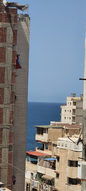 A coastal urban area with buildings adjacent to the sea, featuring balconies and visible sea views. - One Minute To The Sea-Asafra Beach 
Fast WiFi - AC - Family Friendly (Alexandria Governorate)