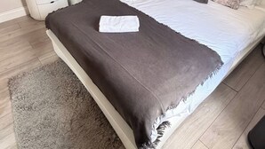 A bedroom with a bed, a wardrobe, a dresser, and a rug. - Marble Arch Elevator Ac - 3 Bedroom Apartment (London)
