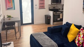 A compact living space with a kitchenette, a dining area, and a seating area with a sofa and ottoman. - Cozy 1-bedrm apartment with AC in vibrant Miami near Wynwood & Design District! (Miami)
