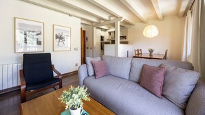 A living room with a sofa, a wooden coffee table with a plant, and framed pictures on the wall. - La Molina: Ski-in apartment with private parking (Alp)