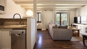 A modern kitchen with a Bosch dishwasher, a dining area with a sofa and a TV, and a balcony with curtains. - La Molina: Ski-in apartment with private parking (Alp)