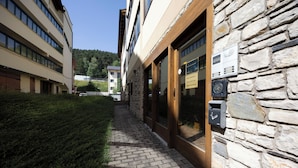 A pathway leading to a building with stone walls and a wooden door. - La Molina: Ski-in apartment with private parking (Alp)