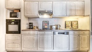 Una cocina equipada con microondas, horno, cafetera y lavavajillas.