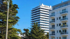 Un edificio de varios pisos con balcones y cielo despejado.