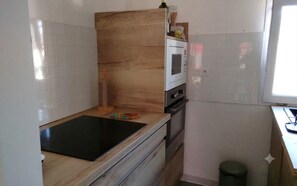 A kitchen with a black induction cooktop, a built-in oven, and a microwave. - Charming house with garden in La Turballe (La Turballe)