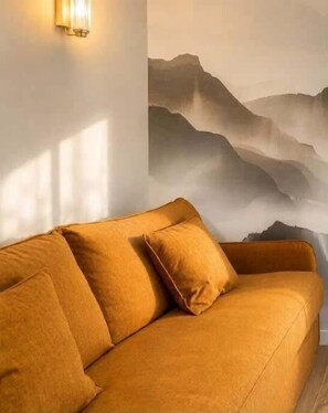 A room with a sofa and a wall-mounted light fixture. - Studio with south terrace & Mont Blanc view (Chamonix-Mont-Blanc)
