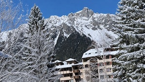 A snow-covered mountain landscape with a building featuring multiple balconies and a snow-covered roof. - Studio with south terrace & Mont Blanc view (Chamonix-Mont-Blanc)