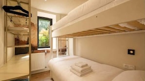 A bunk bed room with a window, a radiator, and a wall-mounted light fixture. - Studio with south terrace & Mont Blanc view (Chamonix-Mont-Blanc)