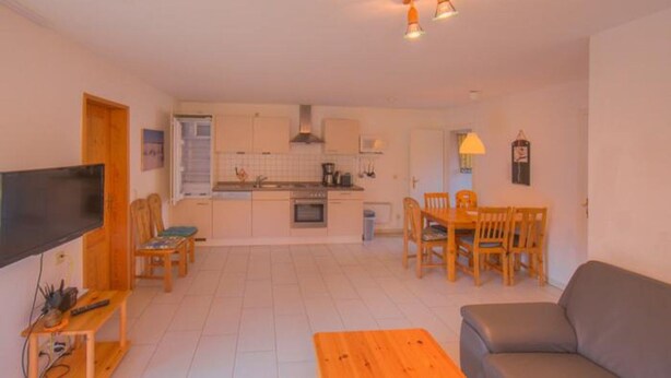 A compact living space with a kitchenette, a dining area, and a seating area. - Komfortabler Doppelbungalow mit Terrasse im Ferienpark Mirow (Mirow)