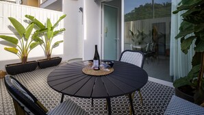 A round table with chairs, a bottle of wine, and potted plants in an outdoor patio area with a tiled floor. - Townhouse in Las Palmas Near Playa Alcaravaneras (Las Palmas de Gran Canaria)