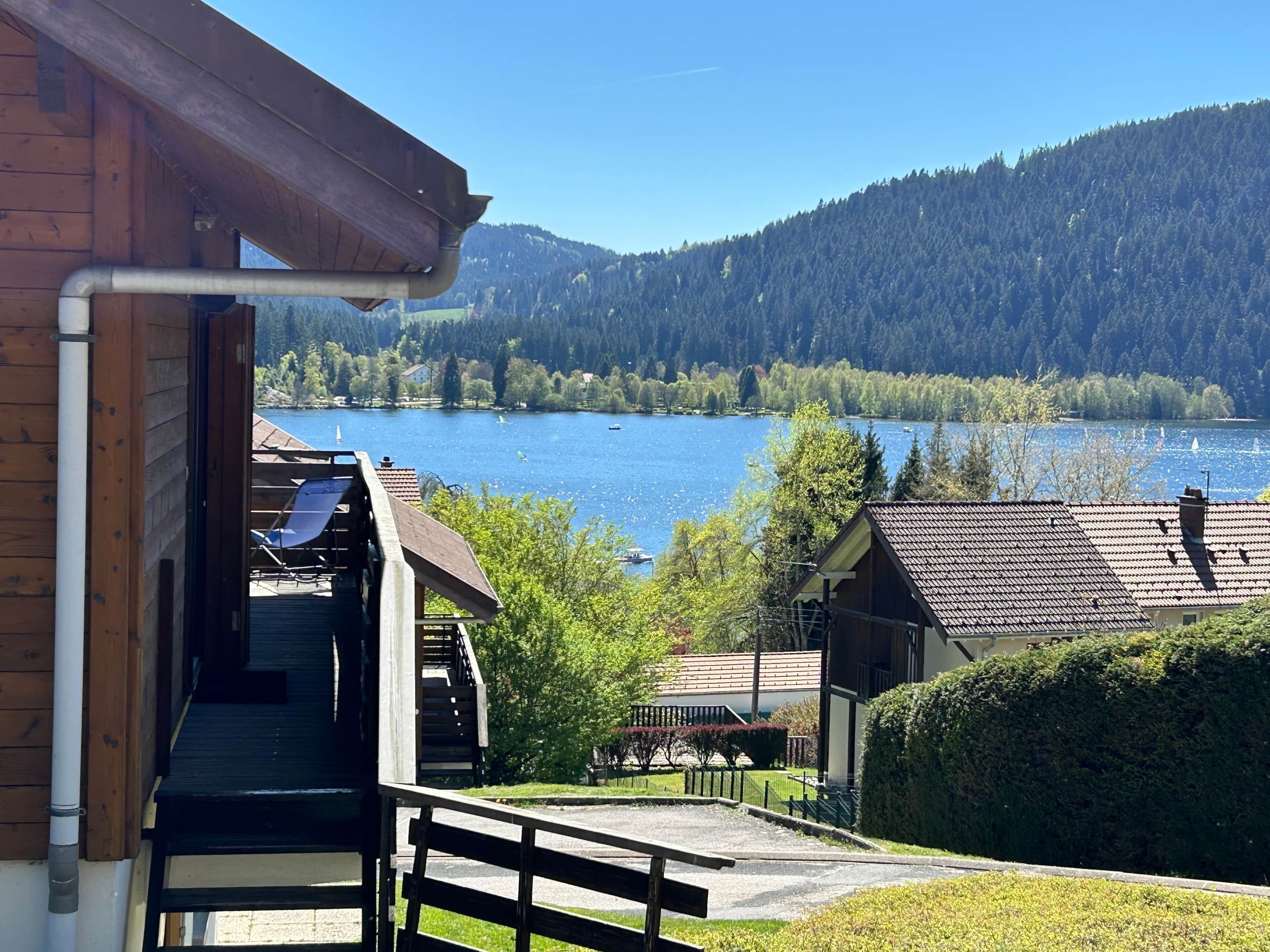 A wooden cabin with a view of a lake and mountains.