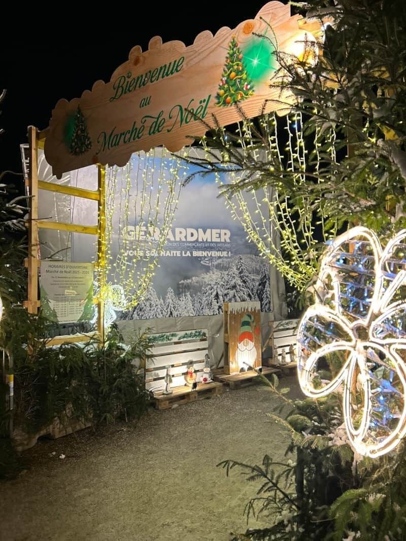 Ein Holzschild mit der Aufschrift 'Bienvenue au Marché de Noël' und einer Weihnachtstanne.