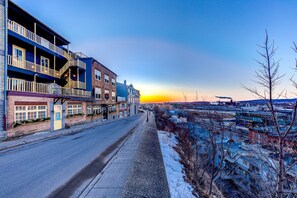 A street view with buildings, a clear sky, and a sunset.