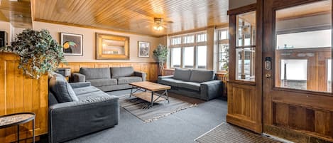 A cozy lobby with wooden paneling, a reception desk, and a large wooden door.
