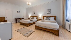 A hotel room with two wooden beds, a desk, and a radiator. - Auberge in Old Quebec -2 bed suite (Québec)