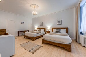 Ein Hotelzimmer mit zwei Holzbett, einem Schreibtisch und einer Heizung.