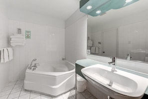 Ein modernes Badezimmer mit einer freistehenden Badewanne, einem Waschbecken und einem Spiegel.