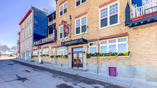 A multi-story building with a prominent sign for "Manor's Remparts" hotel.