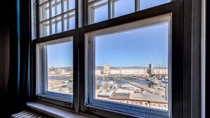 A window with a view of a cityscape, including buildings and a river.