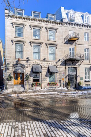 A historic building with a classic facade, multiple windows, and a prominent entrance with a wooden door. - Auberge in Old Quebec - 1 bed suite (Québec)