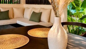 Un intérieur moderne avec un canapé, une table ronde et un vase contenant des plantes séchées.