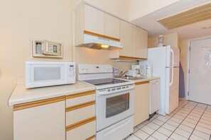 A compact kitchen with a microwave, stove, oven, and refrigerator. - Oceanfront Stay by Skywheel! Yachtsman 1002 (Myrtle Beach)
