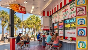 Ein Food-Truck mit einer Speisekarte, auf der Funnel Cakes und Maisdogs beworben werden.