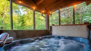 A hot tub with a view of a forest through large windows. - Hot Tub + King Bed +1.4 Miles from Parkway (Sevierville)